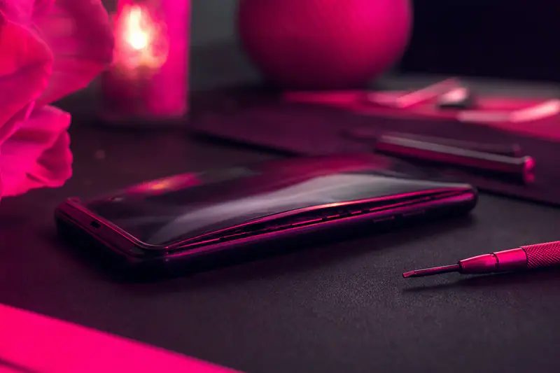 Smartphone posé à plat dont la coque arrière se soulève sur un bord à cause d’une batterie gonflée
