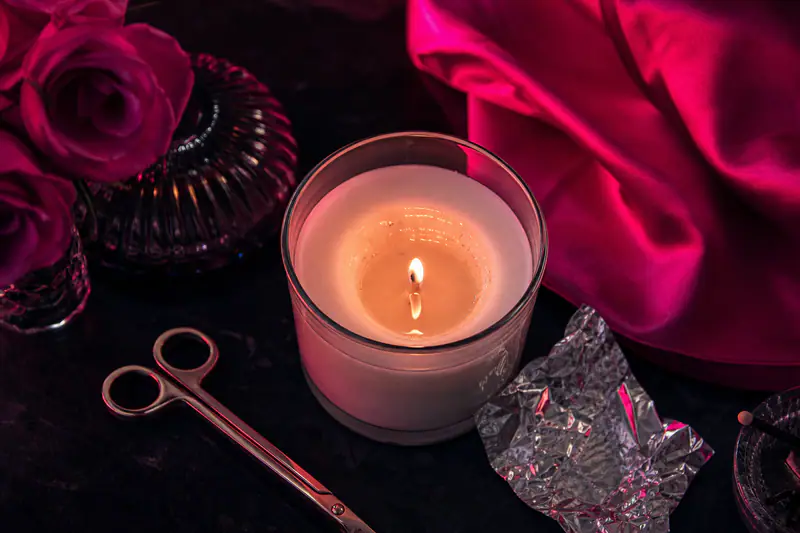 Bougie en pot de verre dont la cire n’a fondu qu’au centre, formant un tunnel autour de la mèche