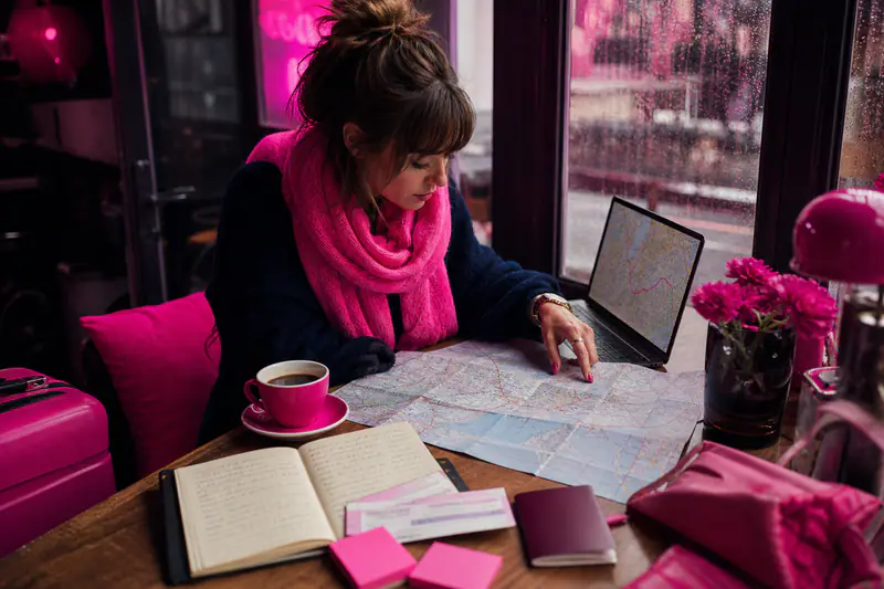 Voyageuse organisant un itinéraire personnalisé avec carte, ordinateur et carnet