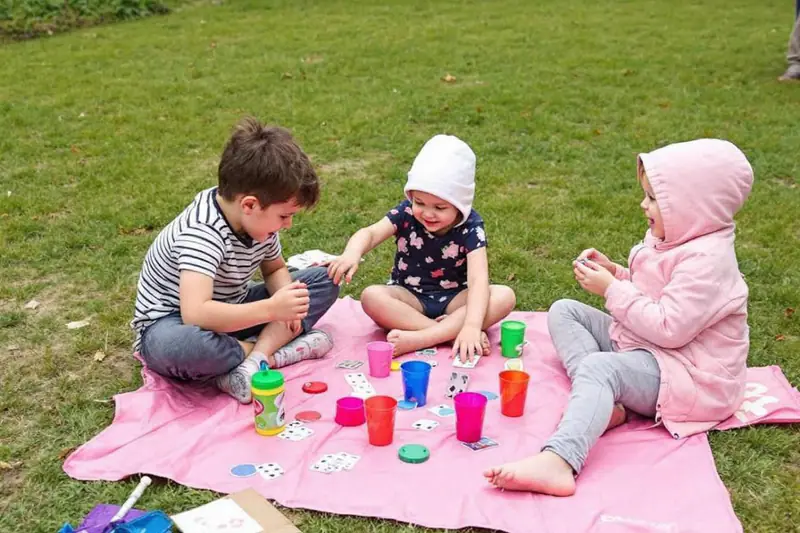 Deux enfants construisent une ville en carton pendant une averse d’été.