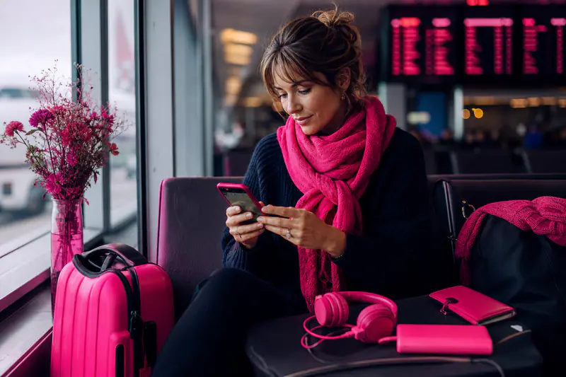 Voyageuse utilisant une carte hors ligne à l’aéroport avec batterie externe