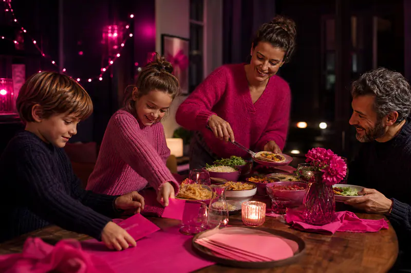 Famille préparant un dîner à thème chaleureux autour d’une table d’hiver
