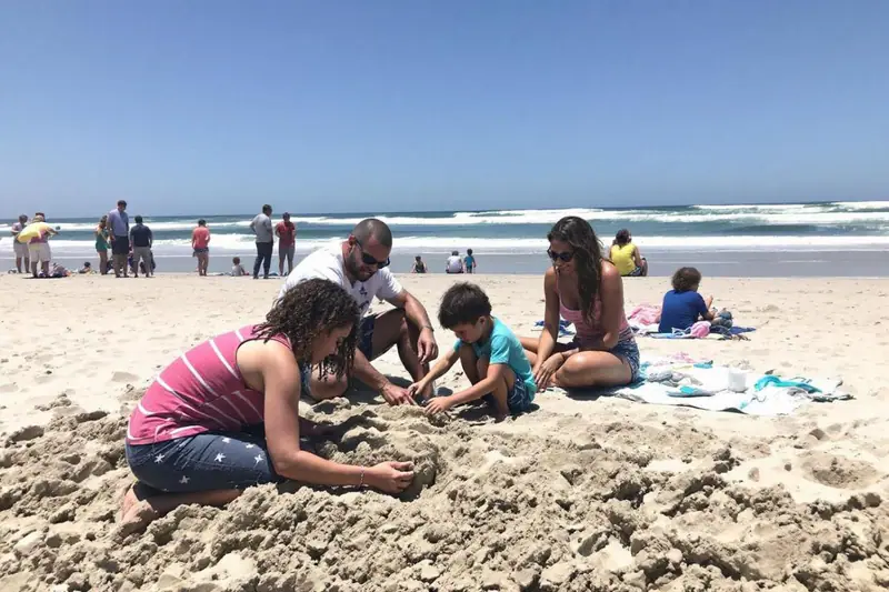 Mère préparant un espace ombragé et sécurisé pour ses enfants à la plage
