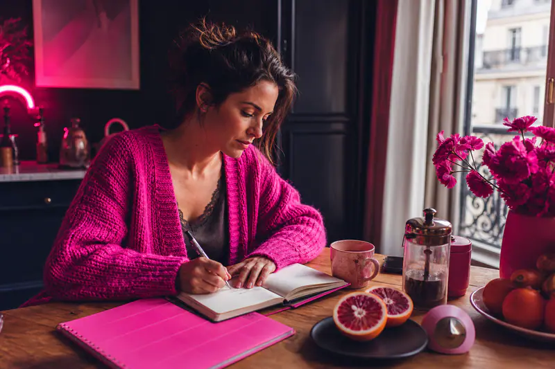 Femme organisant ses objectifs personnels à une table lumineuse en hiver