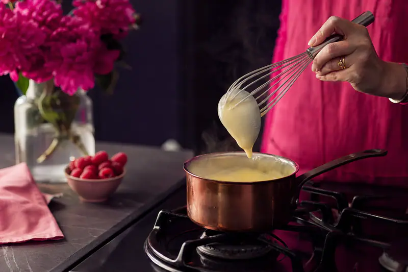 Crème anglaise nappant le dos d’une cuillère au-dessus d’une casserole