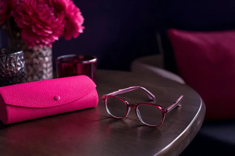 Paire de lunettes d’enfant posée sur une table à côté de son étui coloré
