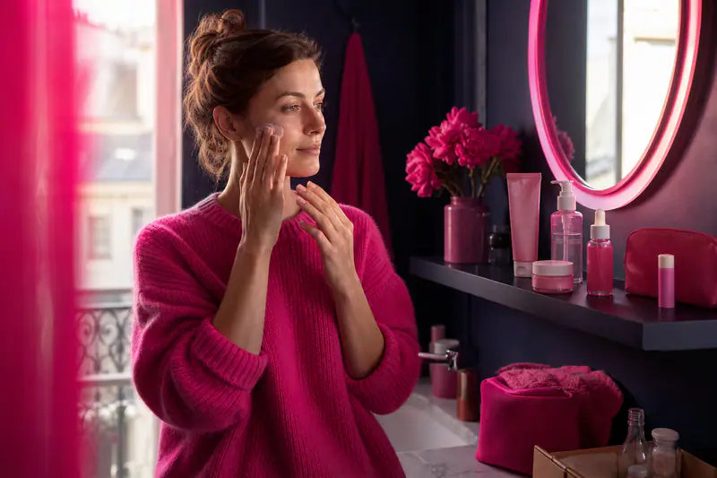 Routine beauté minimaliste avec quelques soins essentiels sur une étagère de salle de bains