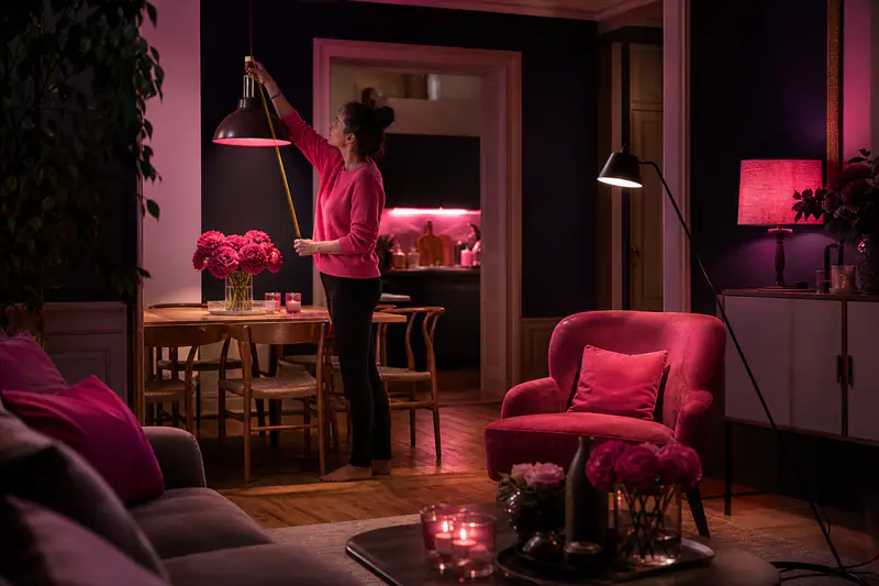 Suspension, liseuse et lampes d’ambiance éclairant un salon-salle à manger.