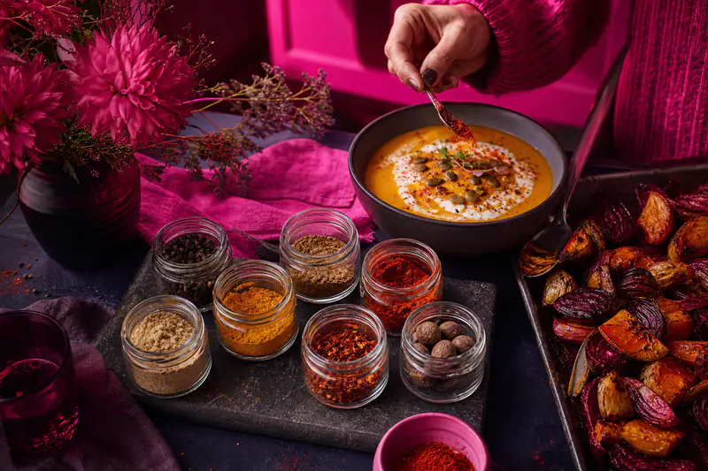 Huit épices ouvertes autour d’une soupe de courge et légumes rôtis.