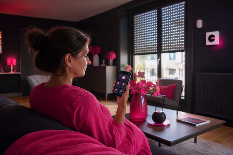 Smartphone pilotant lumières, volets et température dans un salon connecté