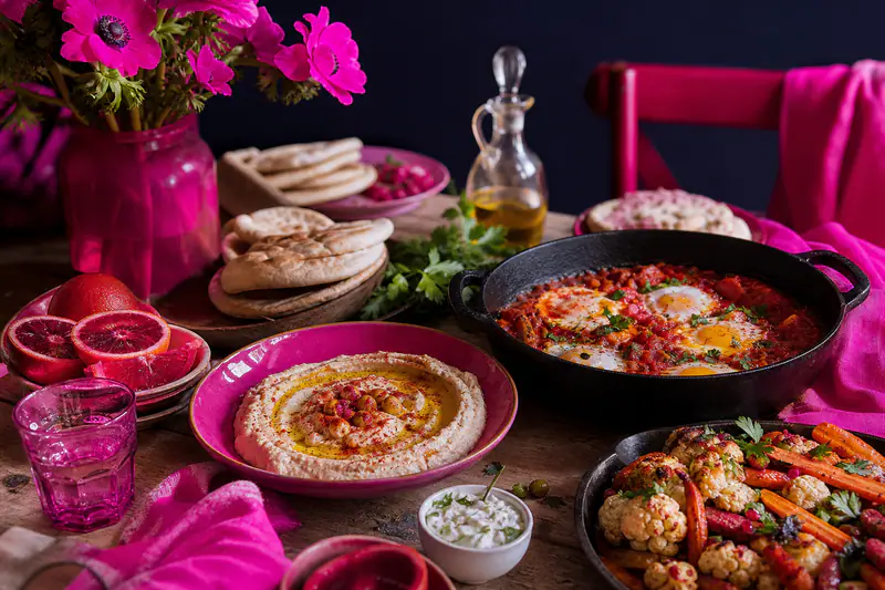 Table d’hiver avec houmous, chakchouka, légumes rôtis et pains pita