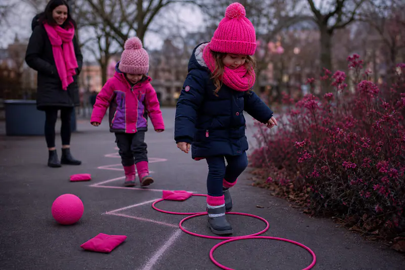 Deux enfants suivent un parcours moteur à la craie dans un parc d’hiver.