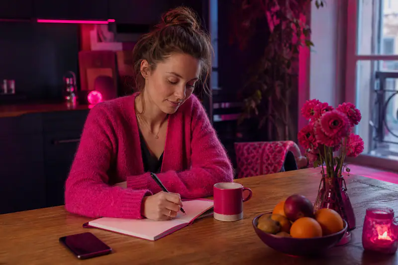 Femme écrivant une routine de bien-être à sa table un matin d’hiver