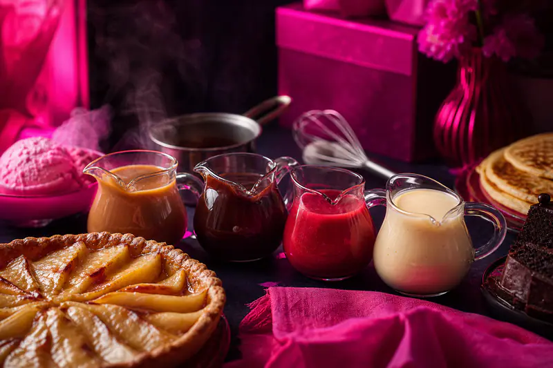 Quatre sauces sucrées maison servies avec gâteaux, crêpes et glace