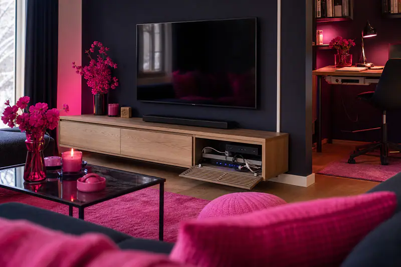Mur TV et bureau avec câbles soigneusement rangés dans des goulottes.