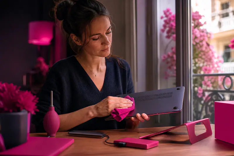Entretien d’un ordinateur portable avec chiffon, souffleur et SSD externe sur un bureau