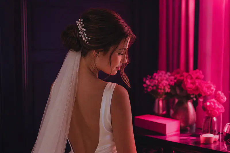 Mariée d’été avec chignon bas texturé, voile ivoire et peigne perlé discret