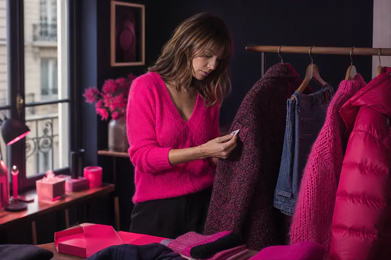 Femme examinant l’étiquette d’un manteau en laine recyclée en automne