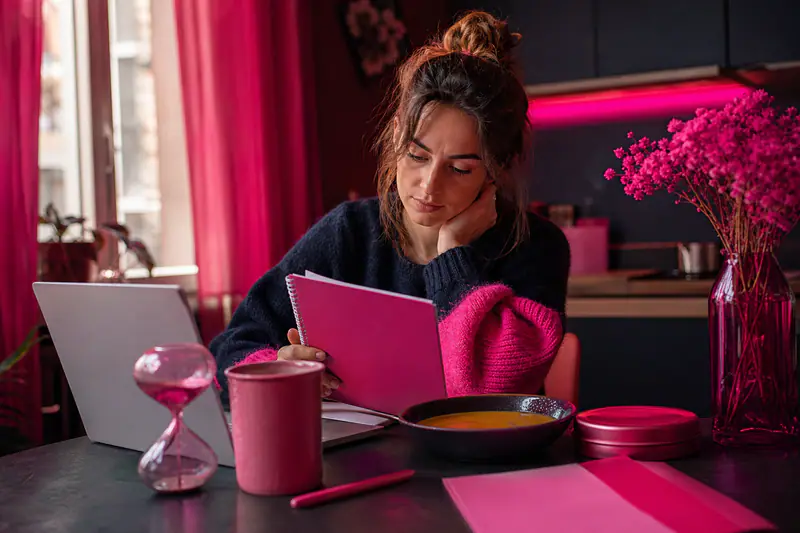 Femme analysant un revers dans un carnet à sa table de cuisine