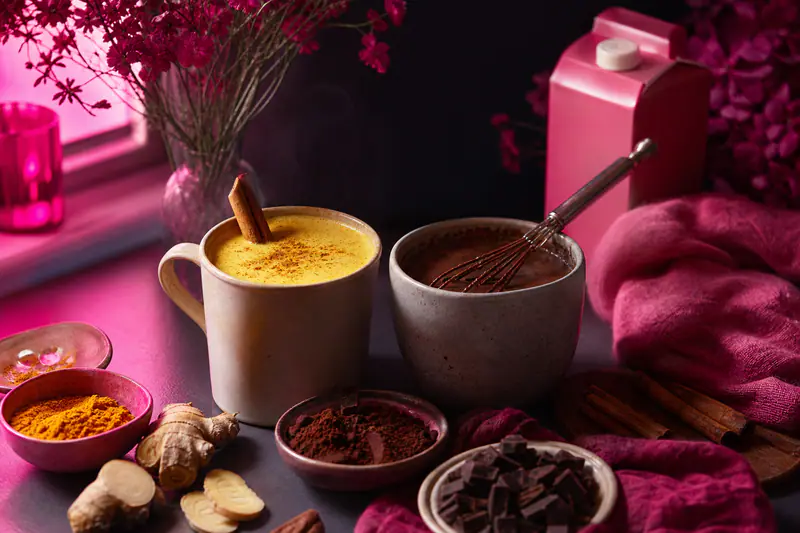 Lait doré et chocolat chaud maison fumants avec épices et cacao